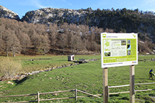 Esplanada davant del refugi, amb panell explicatiu i amb el Paso del Salto del Caballo al fons.