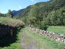 El camí transcorre entre murs de pedra, punt 6.